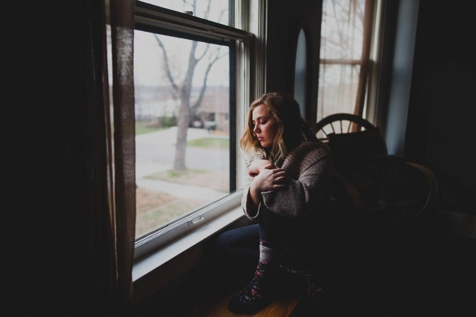 A woman sitting on a window sill